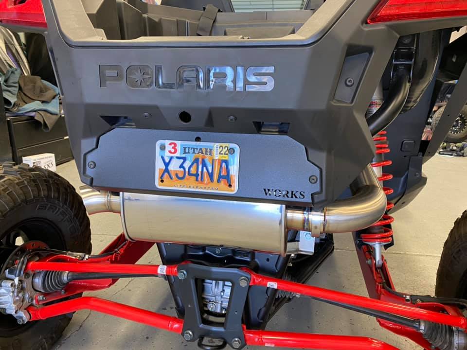 Polaris XP Pro rear license plate panel on UTV with red suspension and custom exhaust; aftermarket UTV parts; high performance upgrades.